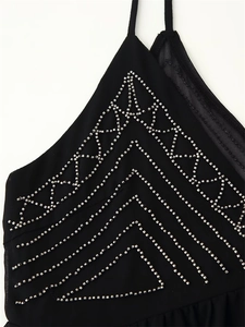 Close-up of silver geometric bead embroidery on a black halter neck top fabric