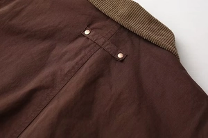 Detail of dark brown jacket with corduroy collar and vintage metal snap buttons