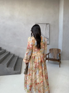Rear view of a floral printed long sleeve dress showing the flowing skirt and elegant silhouette