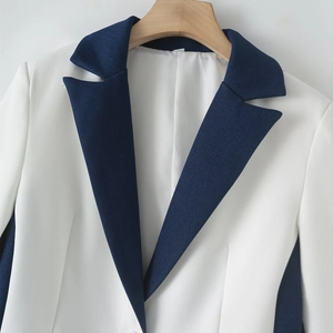 Detailed view of color-block contrast lapel on a crisp white women's blazer