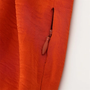 Gros plan détaillé sur la fermeture éclair invisible d'une robe sans manches orange