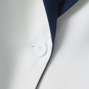 Detailed macro view of white twill fabric with navy collar and a white four-hole button