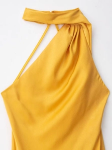 Detail of bright yellow halter neck dress showing elegant pleated chiffon fabric texture