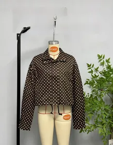 Detailed view of brown polka dot jacket featuring front zipper and adjustable drawstring hem