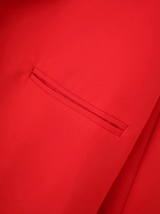 Detailed close-up of a vibrant red blazer featuring high-quality jetted pocket craftsmanship