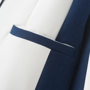 Detailed macro view of white blazer pocket with navy blue piping and twill fabric texture