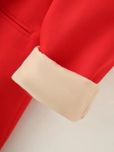 Close-up of red blazer sleeve with folded beige lining and fine stitching details