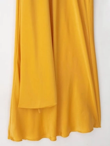 Close-up of bright yellow satin fabric showing smooth texture and elegant silky drape