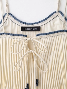 Detail of contrast trim camisole with blue ruffled neckline and beaded bow tie