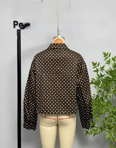 Rear view of a dark brown polka dot bomber jacket with short loose fit design