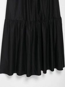 Detail shot of tiered ruffles on a black midi dress with smooth cotton-blend fabric