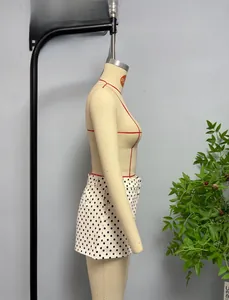 Detailed side view of high-waisted white shorts with black polka dots on a mannequin