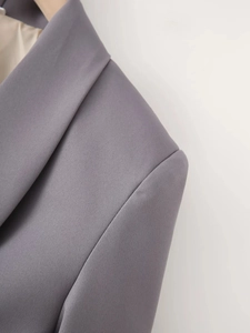 Detail view of mauve shawl lapel blazer showing fabric texture and shoulder tailoring