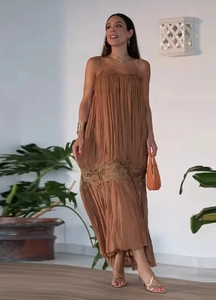 Detail of caramel pleated maxi dress featuring delicate lace trim hem and flowing fabric