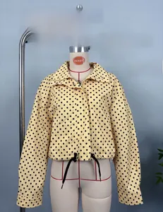 Detail view of yellow polka dot cropped jacket with zipper and adjustable drawstring hem