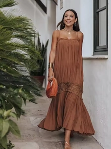 Detail of pleated caramel maxi dress featuring intricate lace embroidery and boho style