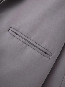 Detail of a precise welt pocket on a grey shawl collar blazer with high quality stitching