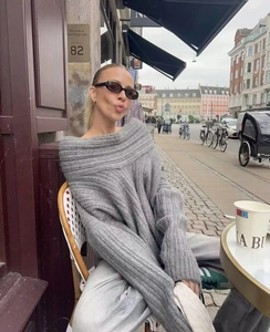 Detail shot of grey oversized off-shoulder knit sweater with ribbed texture