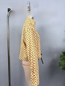 Detail view of yellow seersucker bomber jacket with black polka dots on a mannequin