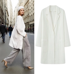 Detail of white mid-length blazer coat featuring classic lapels and large patch pockets