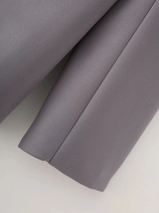 Detailed close-up of premium gray woven fabric texture and seamless stitching on a blazer