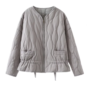 Detail of light grey quilted jacket with wave stitching and elasticized waist design
