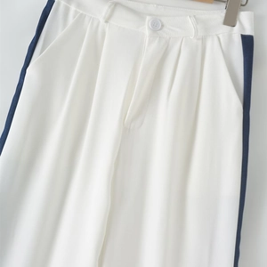 Detail of white trousers with blue side stripes and waist button closure