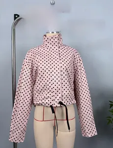 Detail of pink polka dot bomber jacket featuring a stand collar and adjustable hem drawstring