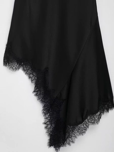 Detailansicht aus schwarzem Satin mit feiner Wimpernspitze am Saum des eleganten Kleids