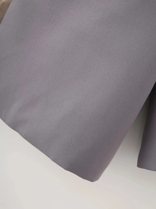 Close-up of grey shawl collar blazer fabric showing high-quality woven texture