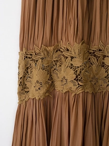 Close-up of caramel pleated fabric with intricate floral embroidery lace details