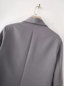 Back view of a grey shawl collar blazer with textured fabric and a center seam on a hanger