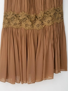 Detail of bohemian pleated dress with intricate floral lace embroidery and texture