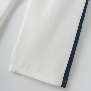 Close-up of white woven fabric with contrasting side stripes and neat stitching