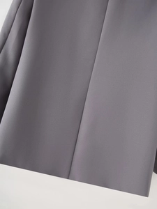 Detail of grey shawl collar blazer fabric showing fine twill texture and seamless stitching