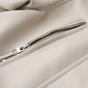 Detail of silver metal zipper and cream leather texture on biker jacket for women