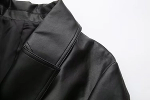 Close-up of premium black faux leather texture with detailed stitching on jacket collar