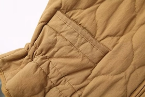 Macro shot of wavy quilted texture and elastic cuff detail on a brown padded jacket