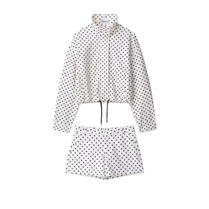 Close-up of stand-up collar and black polka dot pattern on white seersucker bomber jacket