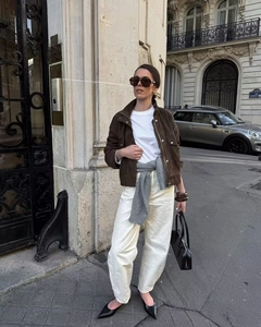 Close-up of brown suede cropped jacket with white t-shirt and wide-leg trousers