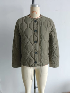 Close-up of olive green quilted jacket showing round neck and black button closure