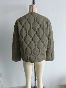 Macro shot of army green onion-quilted jacket showing round neck and smooth texture