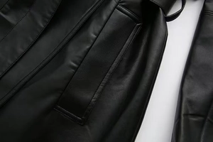 Macro detail of high-quality black faux leather coat featuring welt pocket and stitching