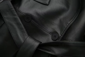 Detail of premium black faux leather jacket showing fine texture and double-row stitching