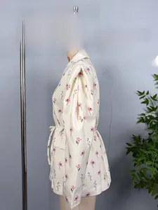 Détail du blazer à fleurs crème avec épaulettes et ceinture à nouer à la taille