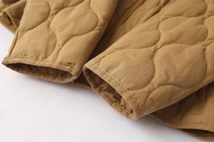 Detail shot of brown quilted jacket sleeve with premium wave stitching and reinforced cuff