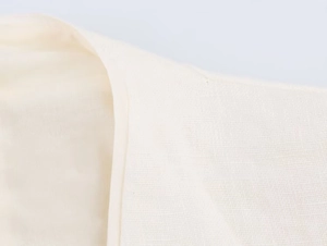 Close-up of ivory cotton linen fabric showing high-quality texture and neat stitching