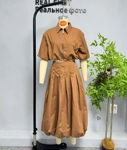 Détail de l'ensemble deux pièces marron avec haut zippé et jupe longue plissée évasée