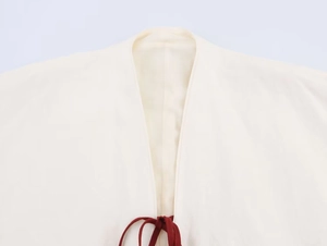 Close-up of linen-blend kimono shirt featuring a V-neckline and dark red ribbon ties