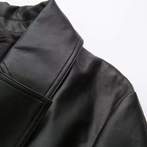 Close-up of lapel and shoulder seam on a black faux leather jacket with fine texture